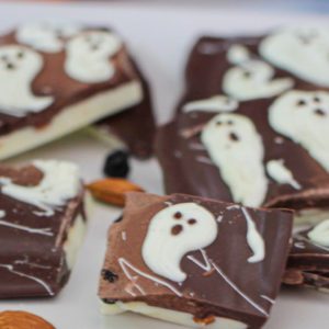 Closeup photo of chocolate bark with blueberries and white chocolate swirled to look like little ghosts