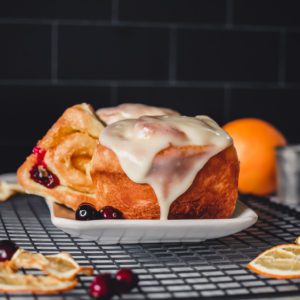 Cranberry studded orange rolls with vanilla orange glaze created and styled by photographer Kate O'Brien