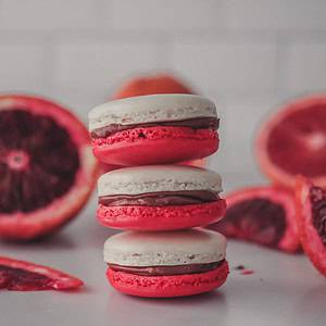 Food photographer closeup shot of cardamom macarons with blood orange curd and chocolate cream cheese filling