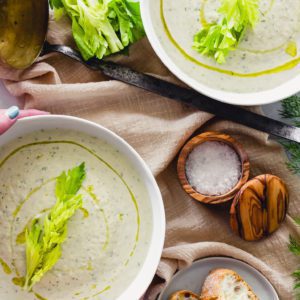 Fresh and creamy celery soup garnished with a sprig of romaine