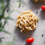 uncooked pasta with rosemary and tomatoes