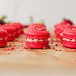 Strawberry basil mini macarons styled on baking parchment