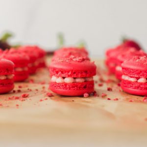 Strawberry basil mini macarons styled on baking parchment