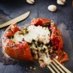food photographer closeup of a baked tomato stuffed with pistachio filling and covered in cheese