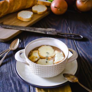 Professional photo of silky french onion soup in a white tureen